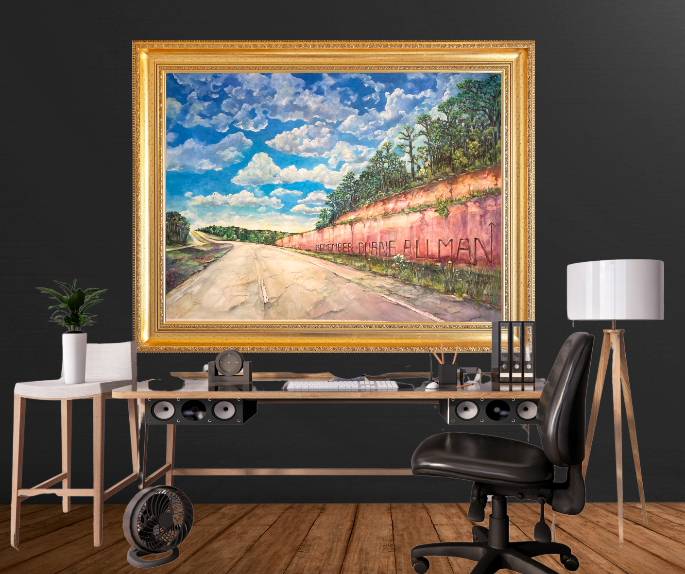 Home office setup with a large framed print of a road and landscape on a black wall.
