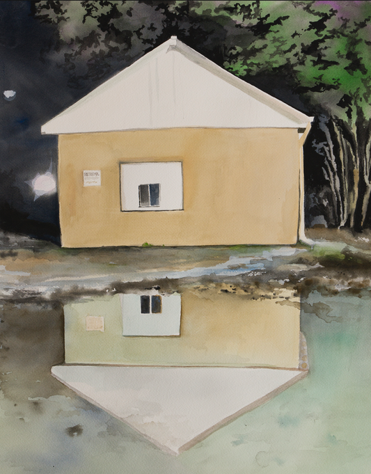 rectangle shape, image of beige tin building at night with building reflected in puddle in the foreground.